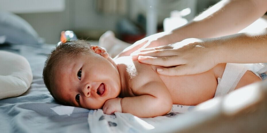 baby on belly smiling getting back massage