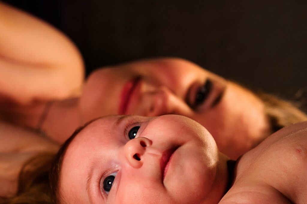 mom and baby laying together on bed